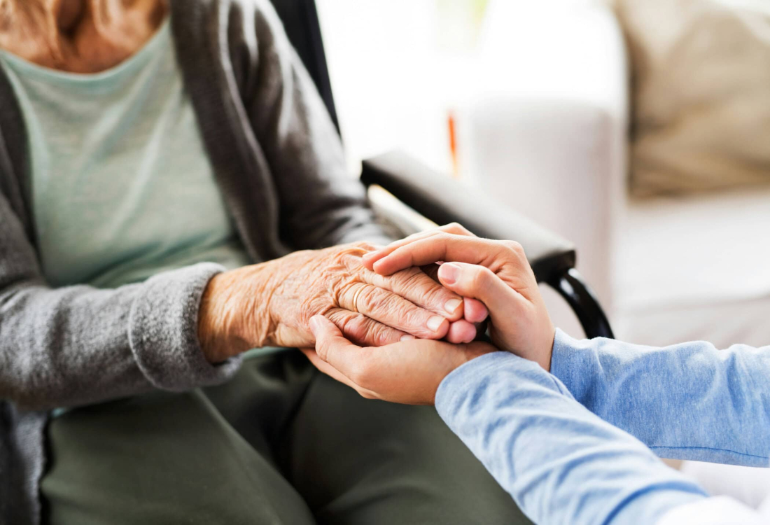 Holding a caring hand between older and younger person