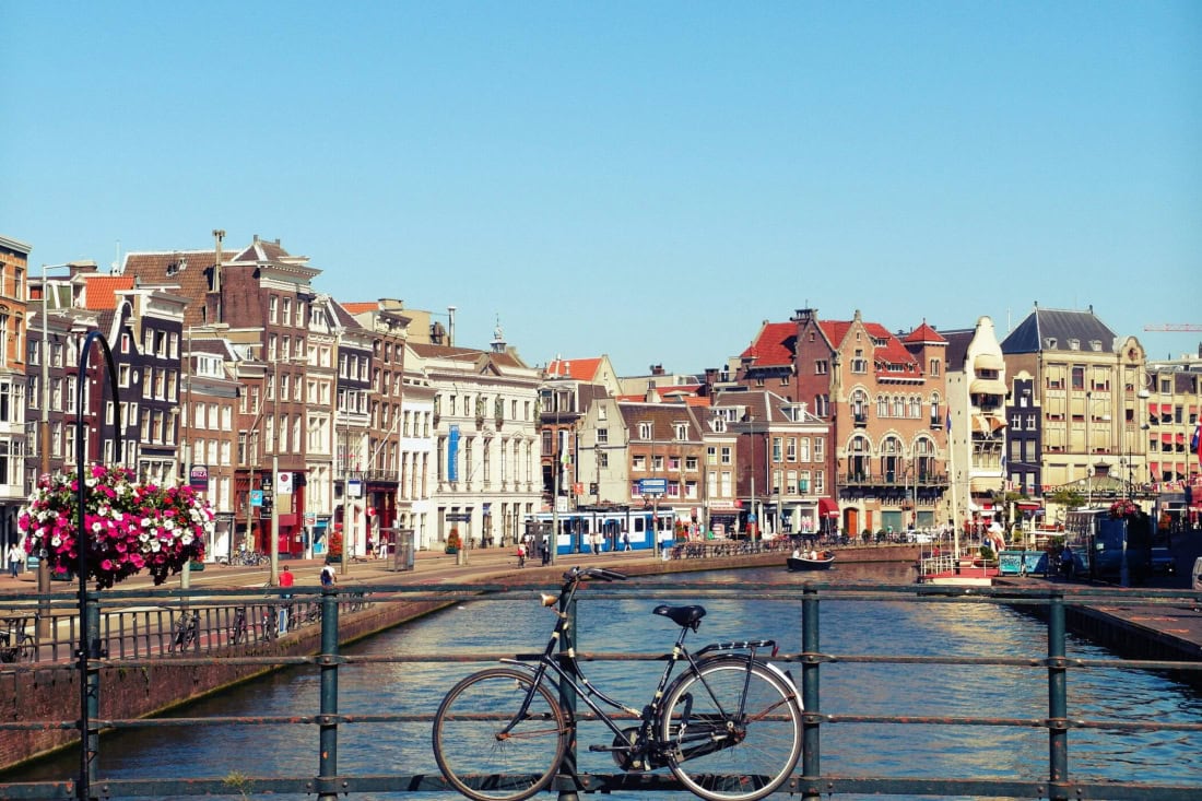 Cycling in front of a historic Dutch city with canals and colourful buildings.